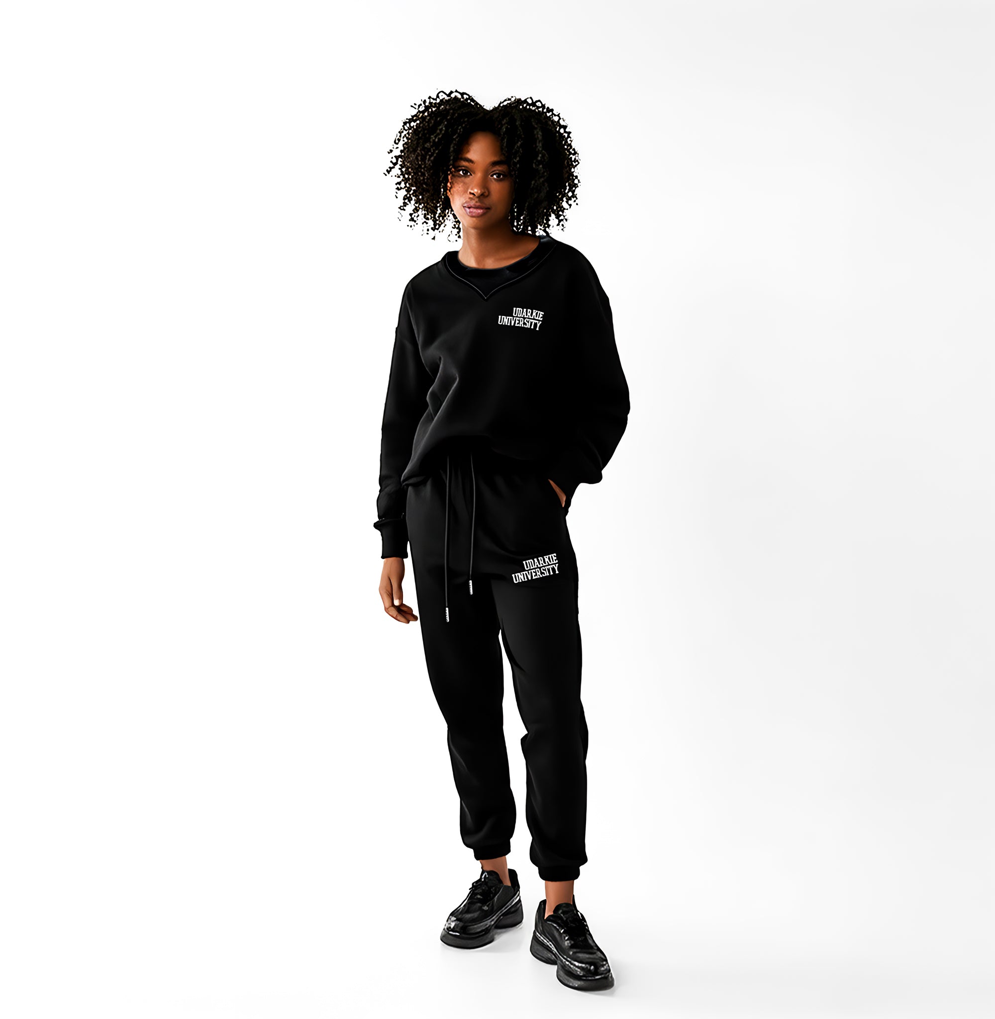 Full-body view of a women wearing a black sweatshirt and sweatpants set with white "UDARKIE UNIVERSITY" print, standing against a white background.