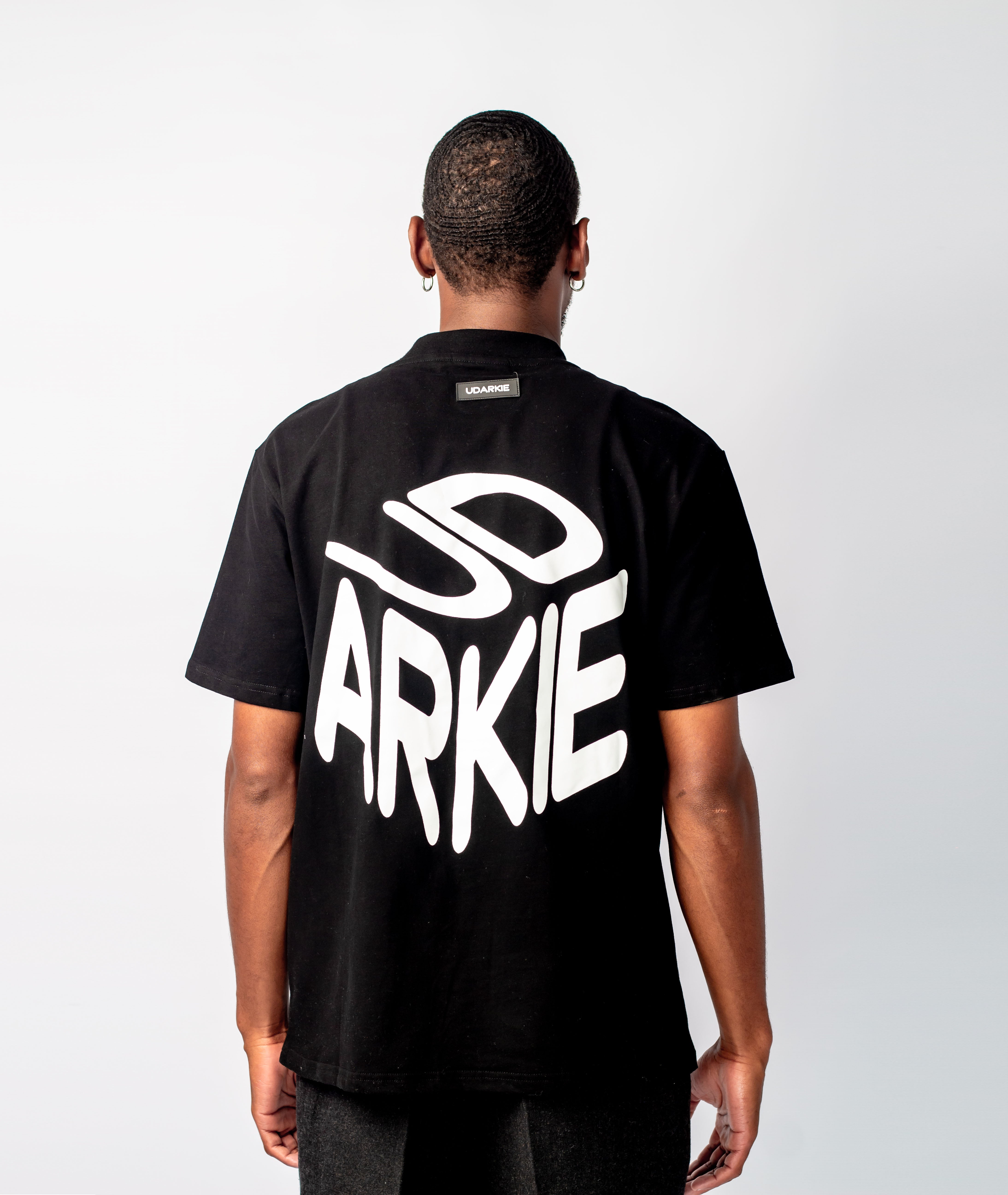 Back view of a black T-shirt with large white stylized text reading "UD ARKIE". Back view of a black T-shirt with large white stylized text reading "UD ARKIE".