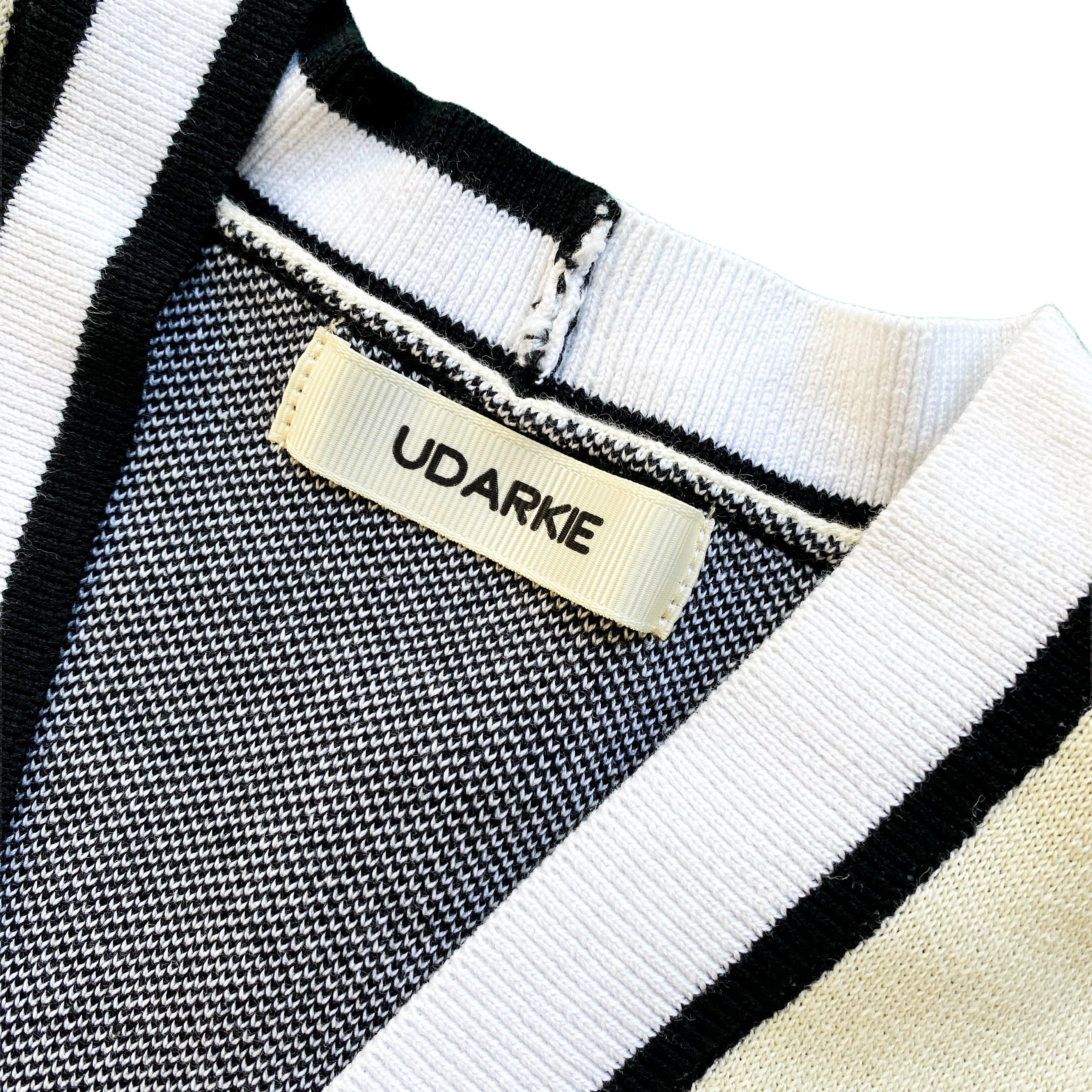 Close-up of a UDARKIE brand label on a varsity-style cardigan