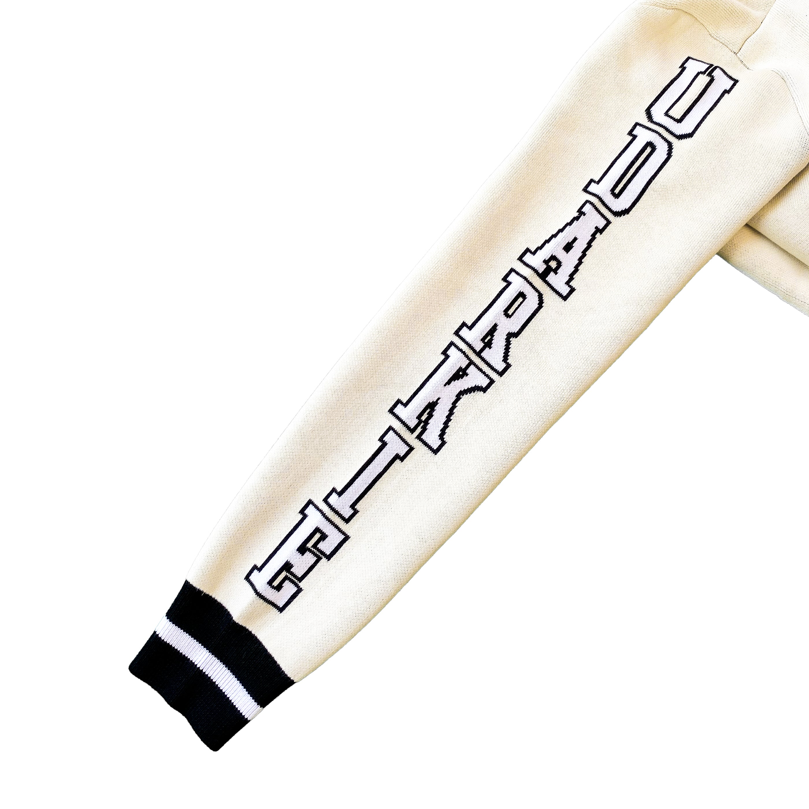 Close-up of a cream white varsity-style jacket sleeve with white "UDARKIE" text