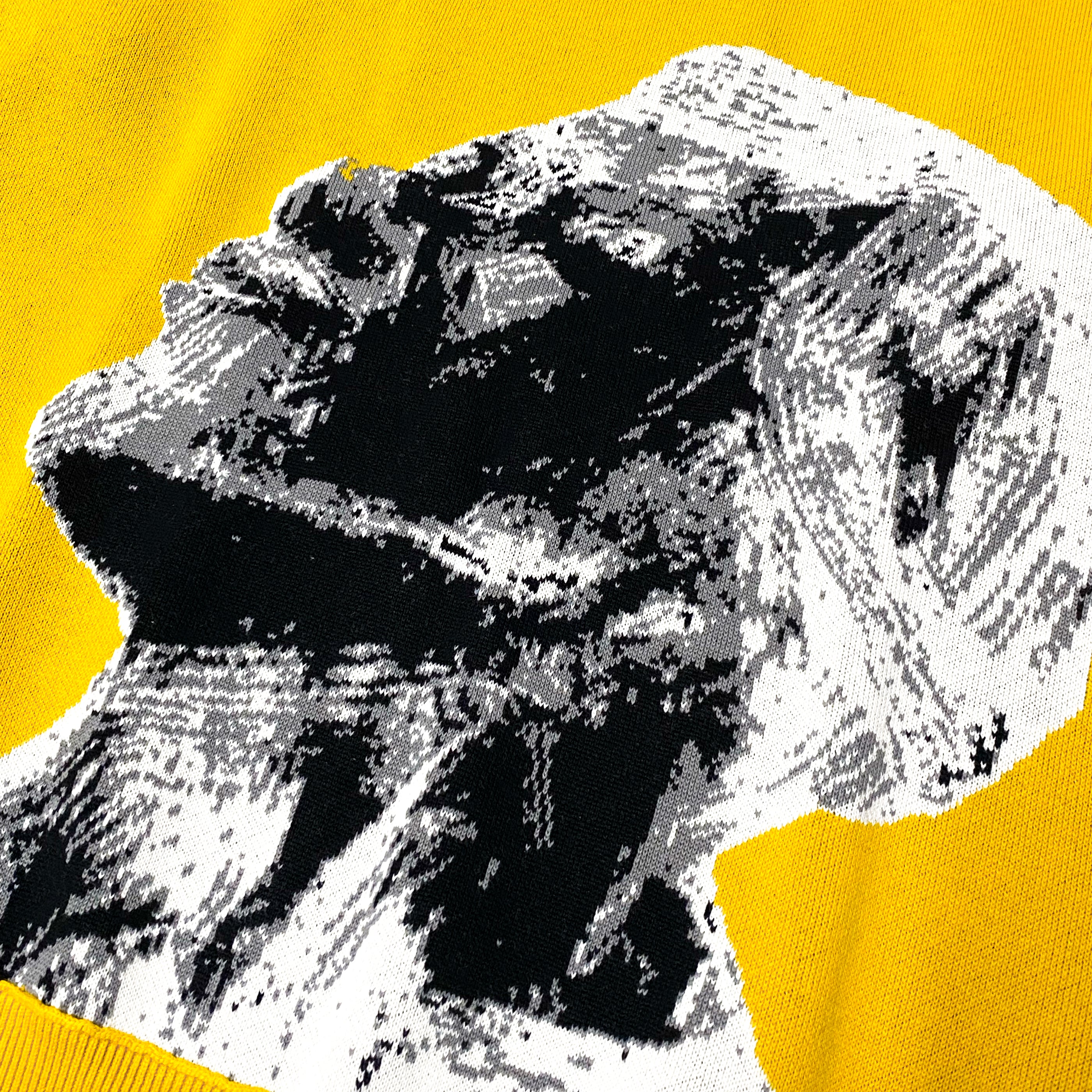 Close-up of yellow fabric with abstract black and white pixelated face design in profile