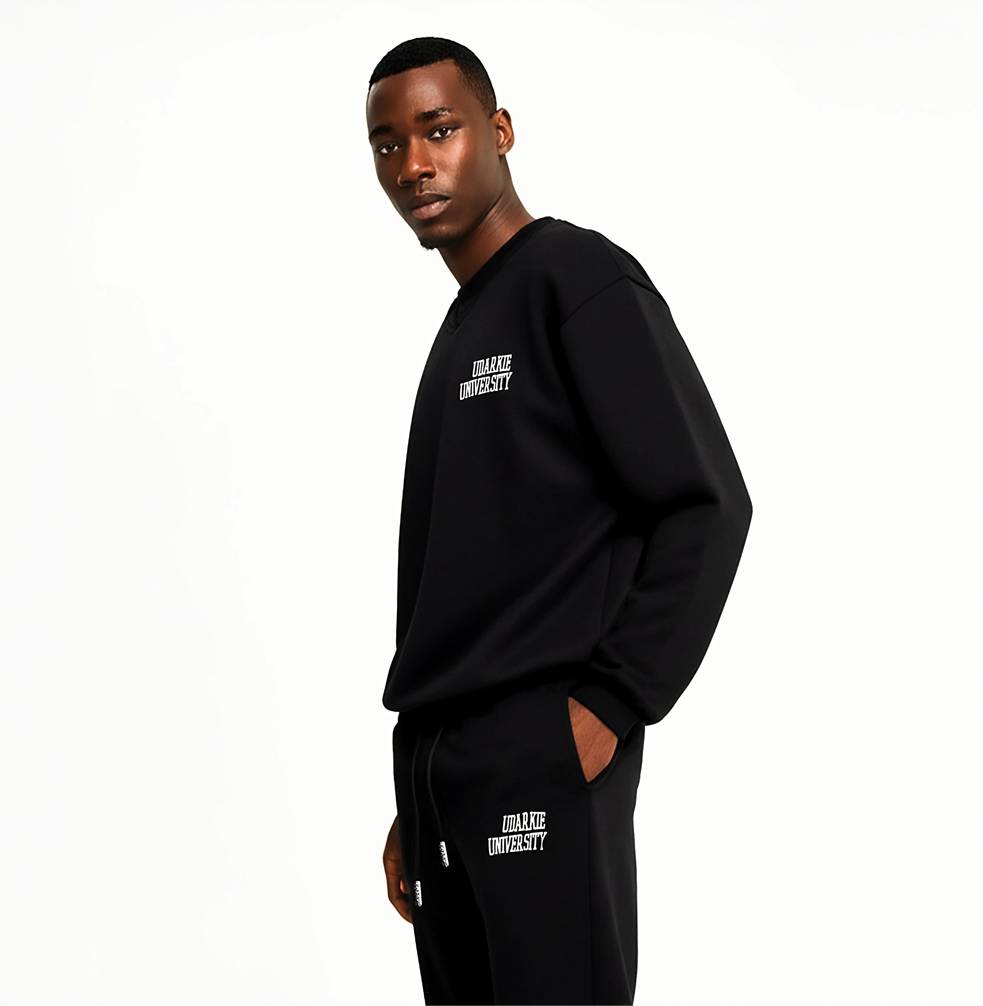 Man wearing black sweatshirt and sweatpants with white "UDARKIE UNIVERSITY" logo.