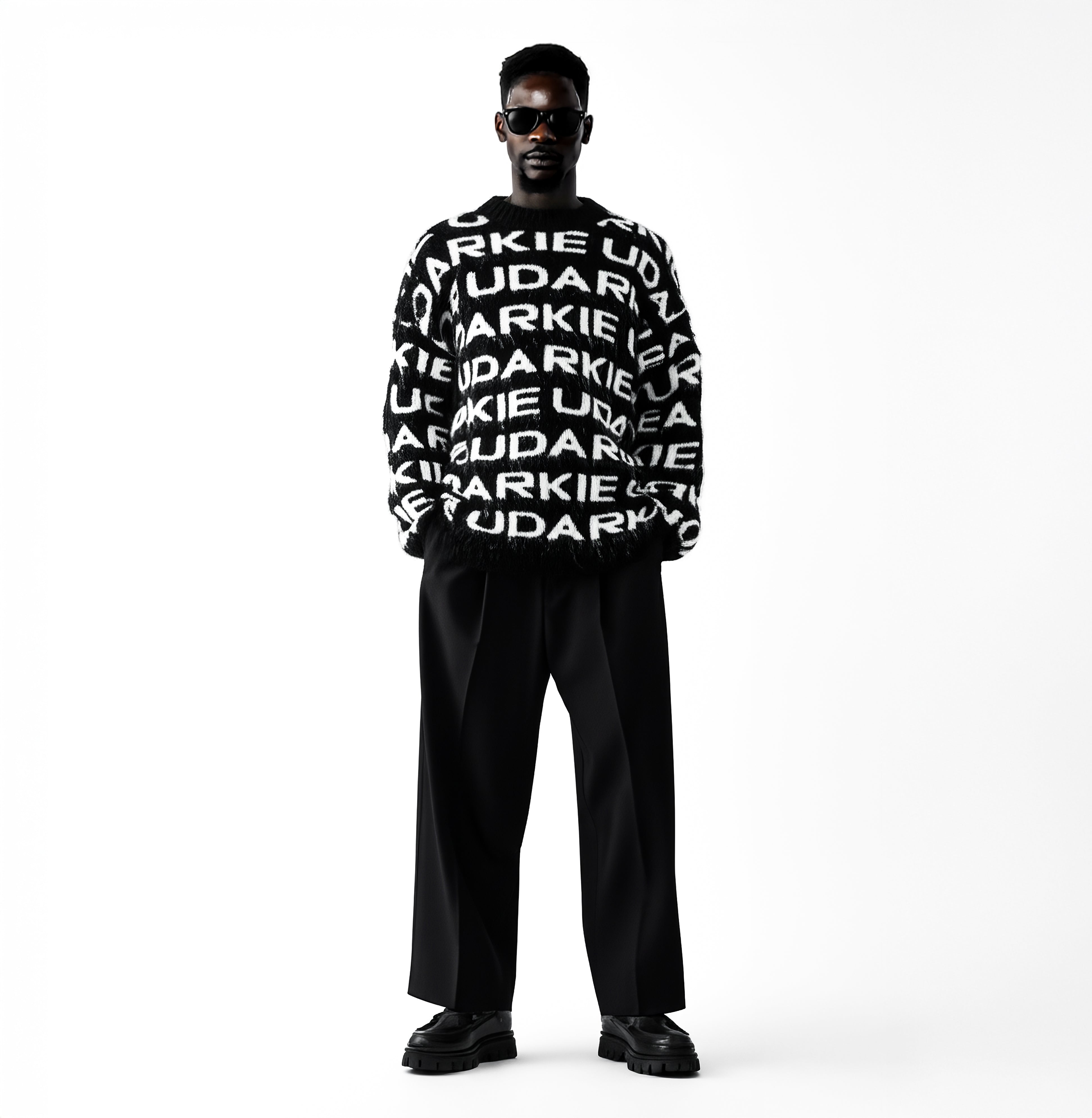 Person wearing a black and white sweater with repeated "UDARKIE" text, paired with black wide-legged pants and black shoes, standing against a white background.