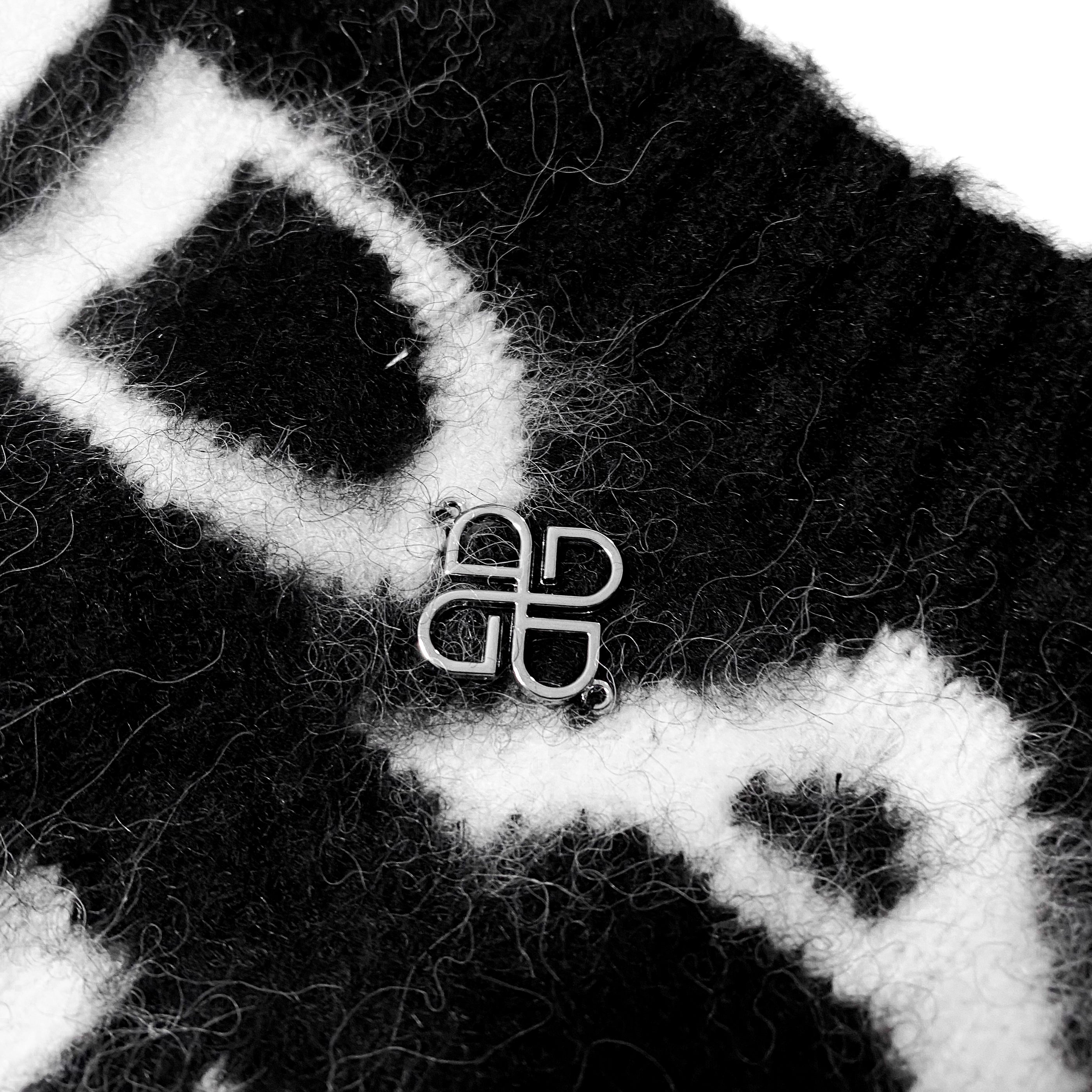 Udarkie metallic pin on a black mohair sweater