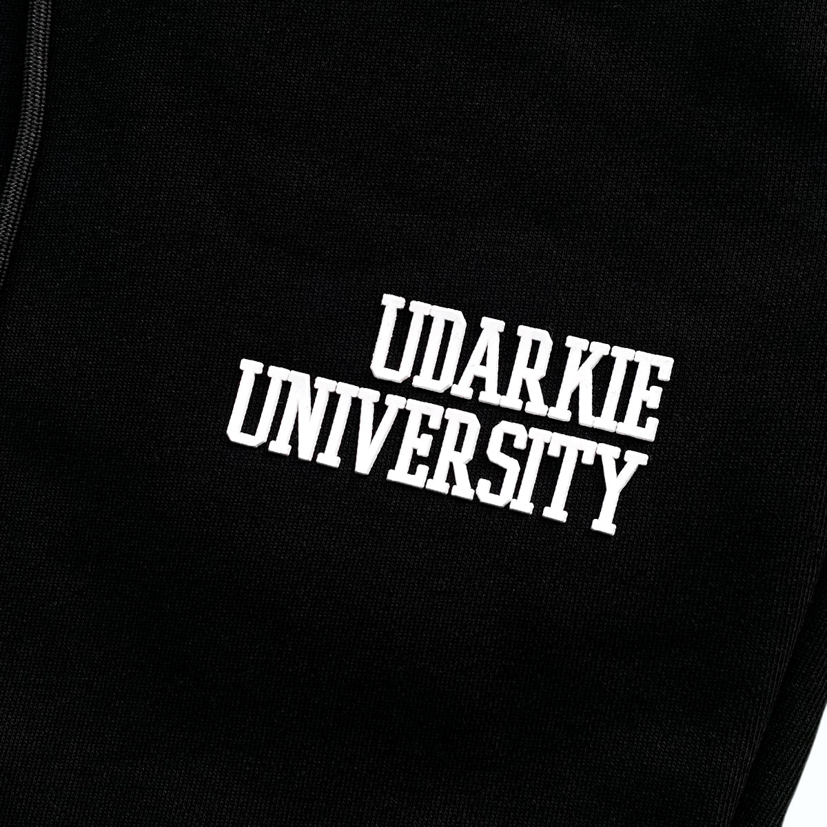 Black sweatpants with white "UDARKIE UNIVERSITY" print on the thigh, featuring drawstring waistband and elastic cuffs.