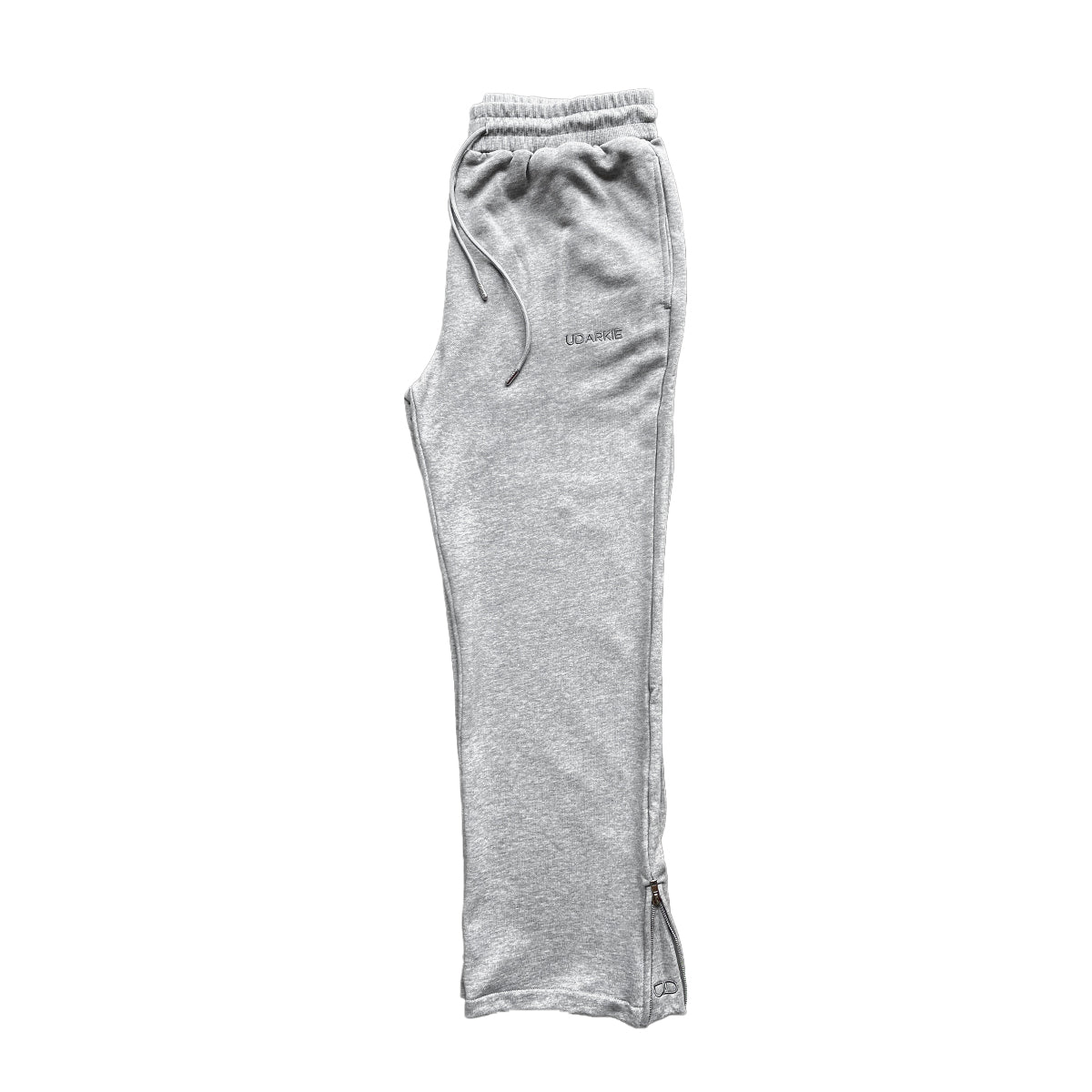 Folded gray trackpants with elastic waistband and drawstring, with "UDARKIE" branding on the upper left thigh.