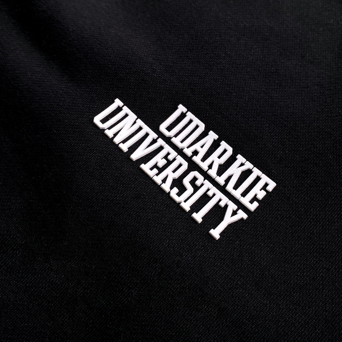 Black sweatshirt with diagonal white "UDARKIE UNIVERSITY" text made from rubber material