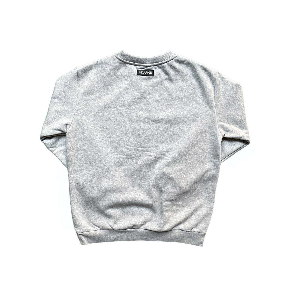 Flat lay of gray sweatshirt showing the back side with a small black label near the neckline displaying "UDARKIE" in white text